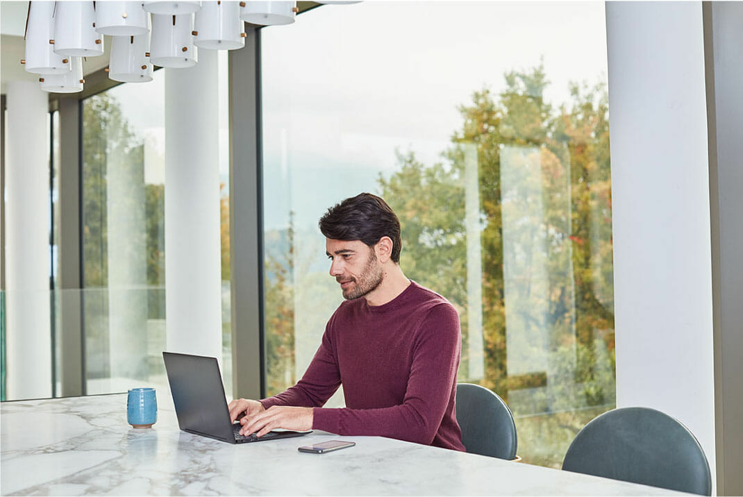 a person sitting at a table using a laptop