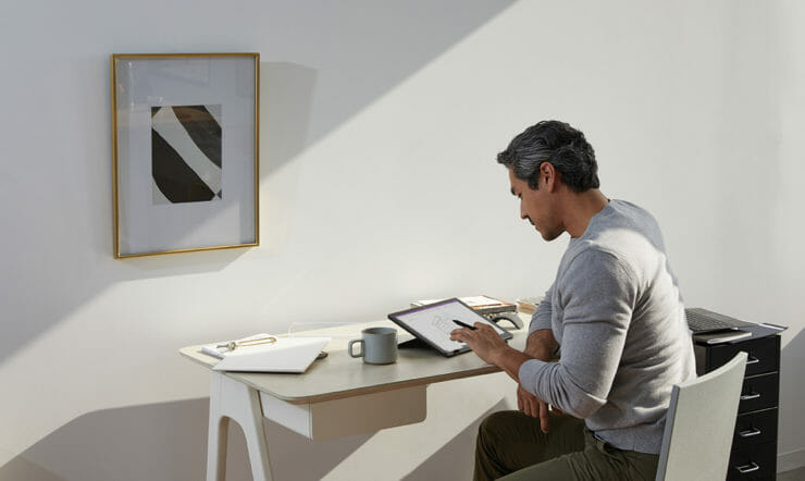 a person sitting at a table using a laptop