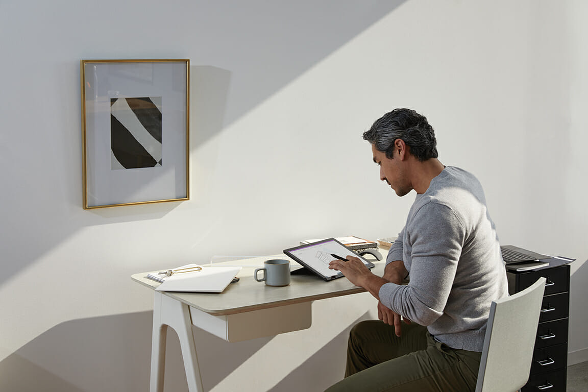 a person sitting at a table using a laptop