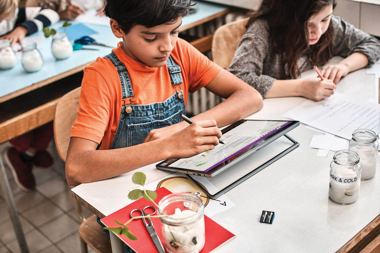 een groep mensen die aan een lijst met behulp van een laptop zitten