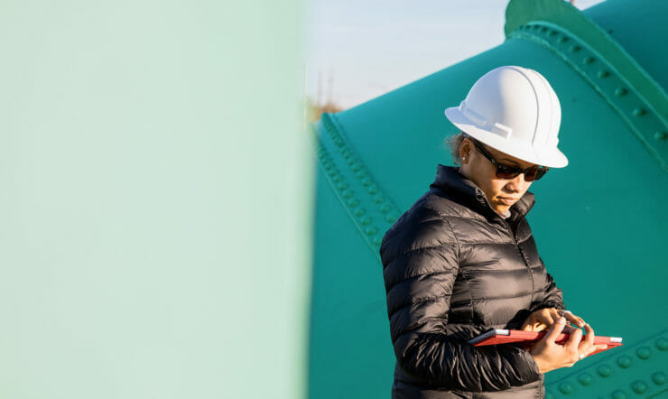 Adult woman in an industry holding a tablet