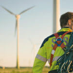 Man walking in front of wind turbines