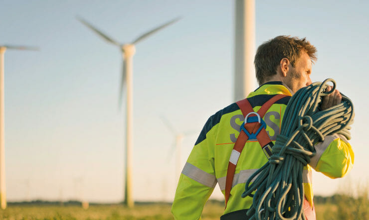 Man walking in front of wind turbines