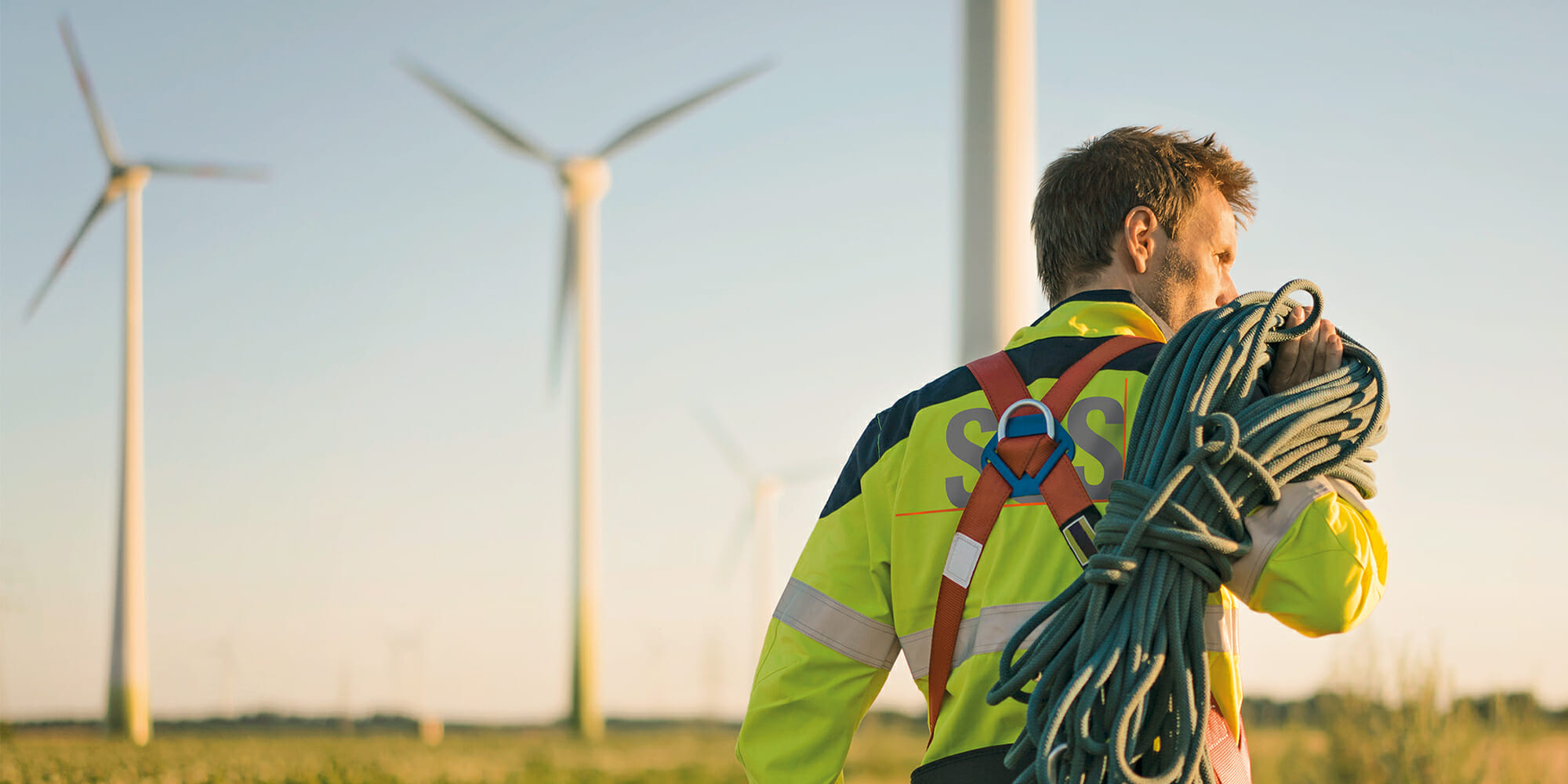 Man walking in front of wind turbines