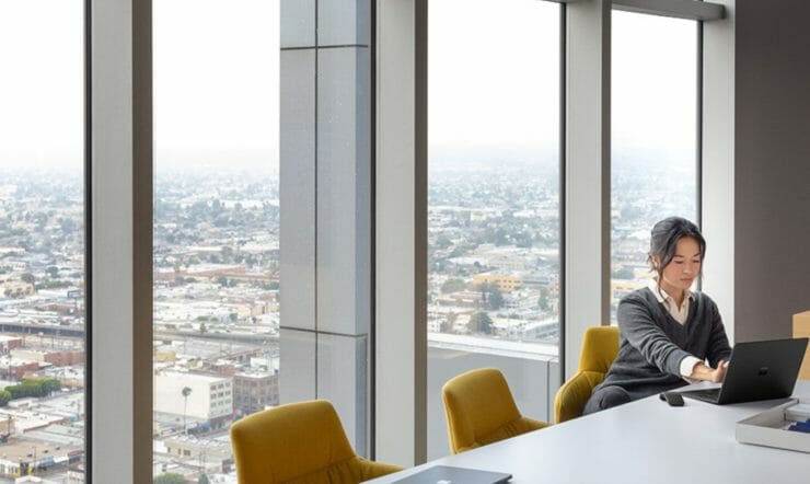 woman behind desk with skyline in background