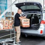 Store associate loading a drive-thru customers’ car with their order.