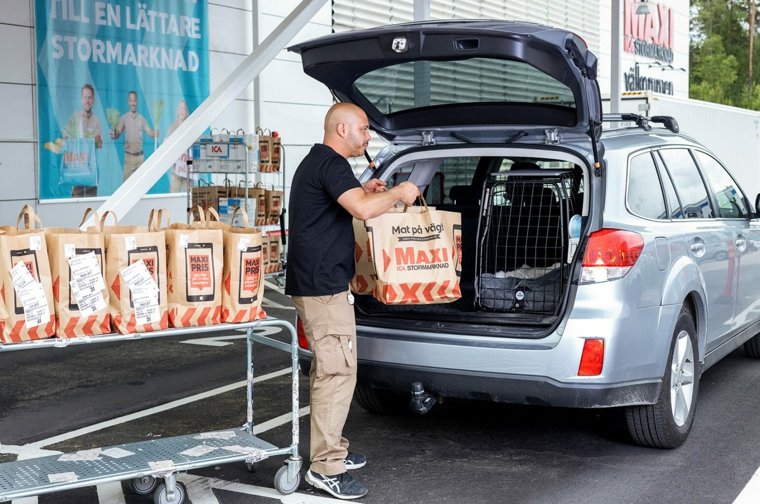 Store associate loading a drive-thru customers’ car with their order.