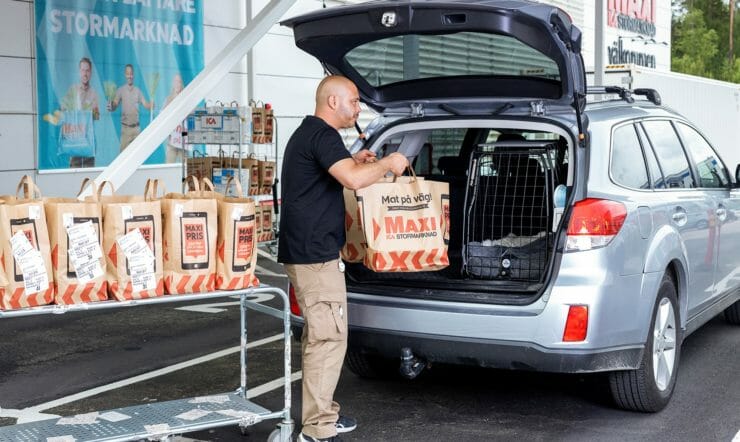 Store associate loading a drive-thru customers’ car with their order.