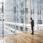 man in front of glass building