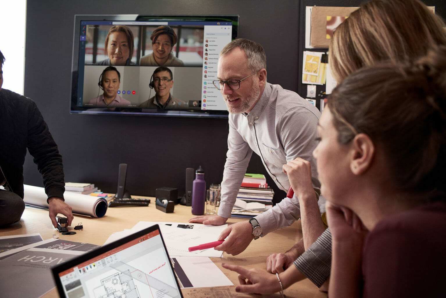 Female & Male employees collaborating using PowerPoint and Microsoft Teams.