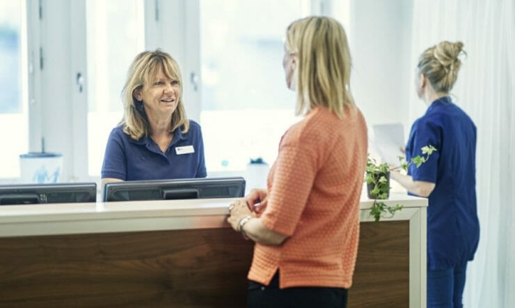 A woman working in healthcare talking to another woman