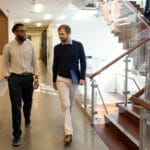 Two men chatting while talking in an office space