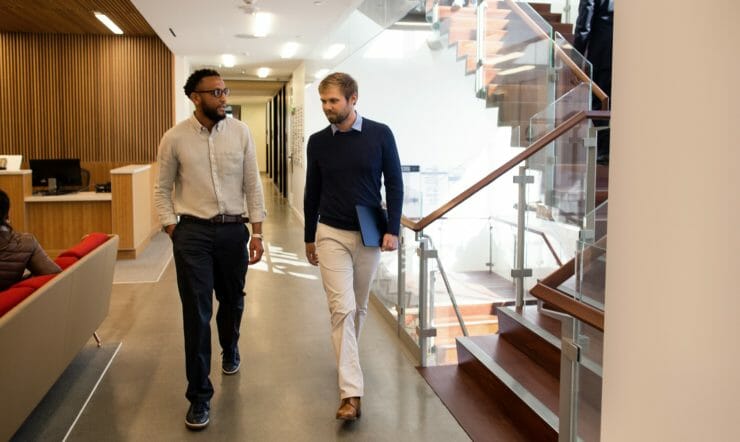 Two men chatting while talking in an office space