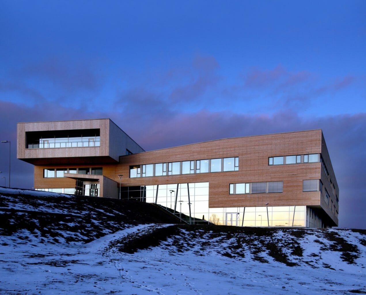 Samas Høgskole i vinterlandskap foran en mørk blå himmel