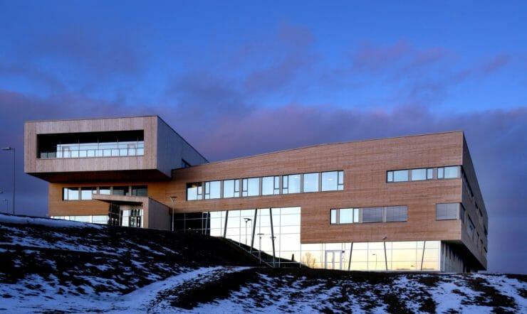 Samas Høgskole i vinterlandskap foran en mørk blå himmel