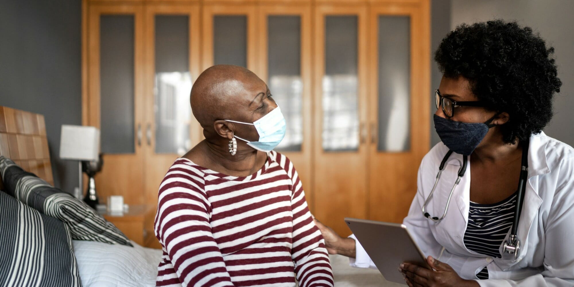 doctor and patient sitting on bed