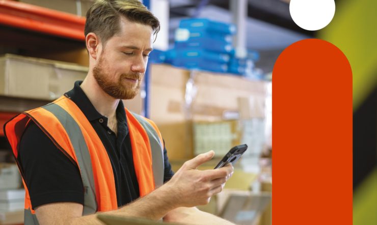 Man in magazijn die met technologie werkt