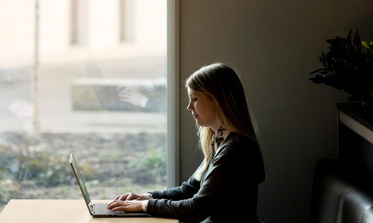 Sara Bergman sitter på en PC foran et vindu