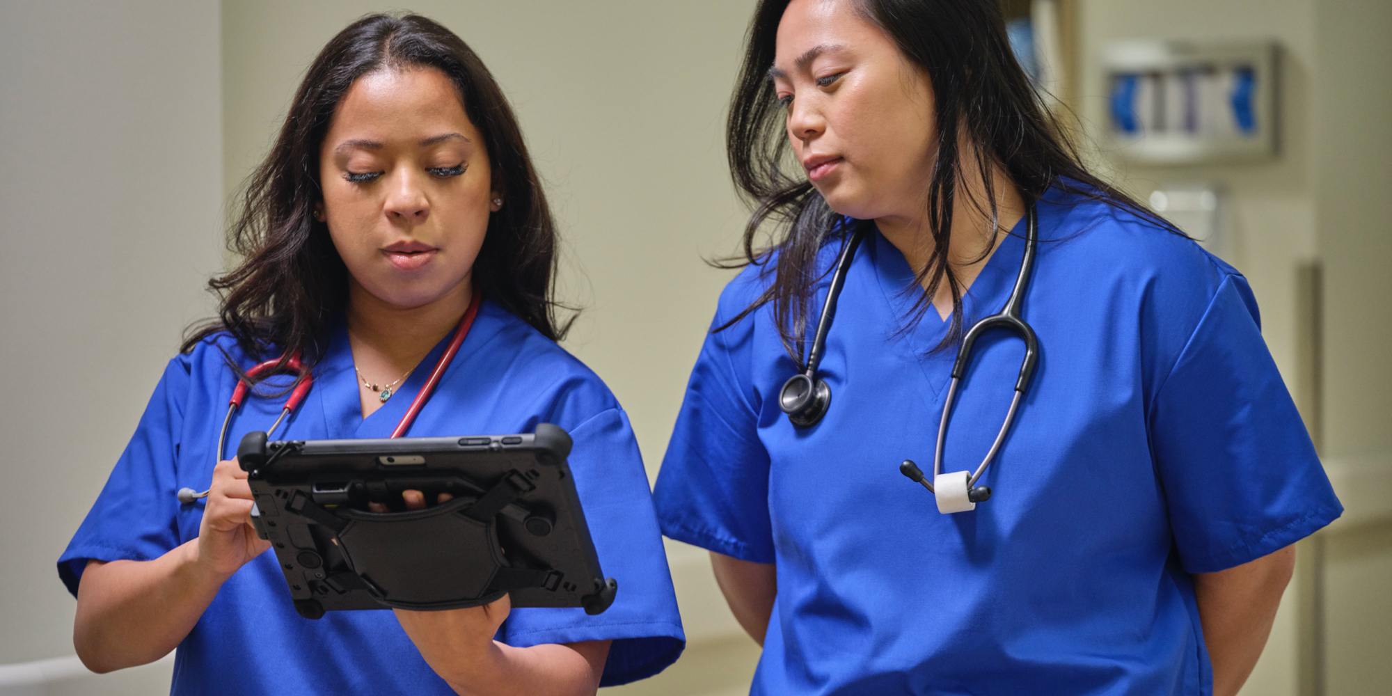 One nurse is holding a Surface Go 3 and Surface Pen while sharing the screen with another nurse.