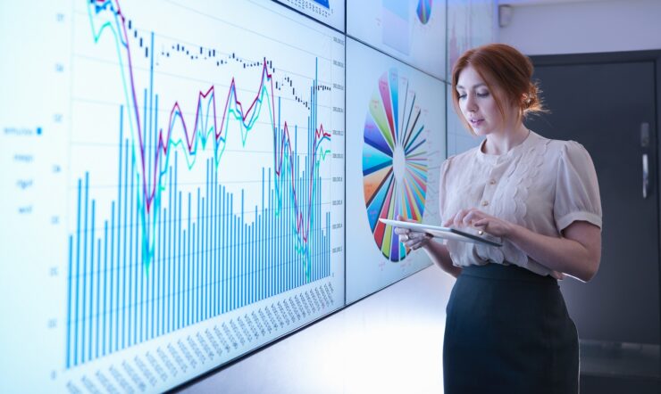 Businesswoman studying graphs on screen with digital tablet