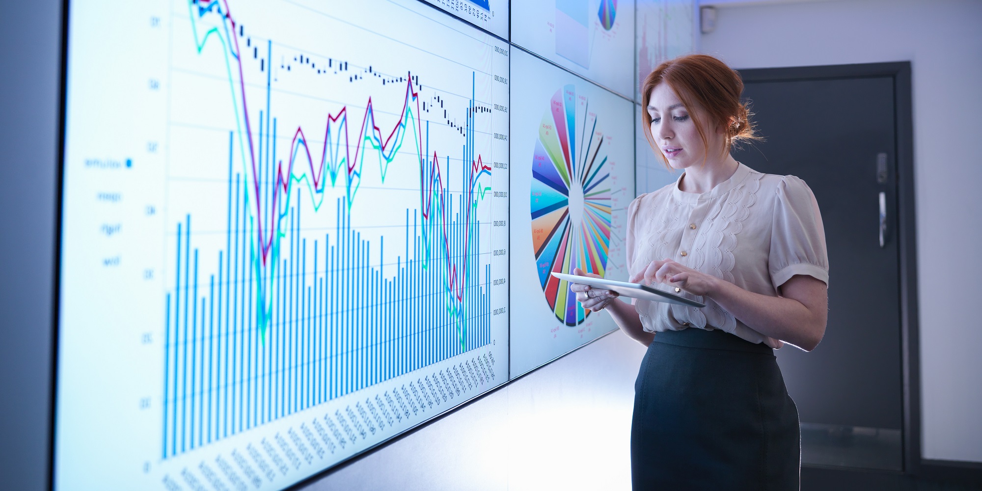 Businesswoman studying graphs on screen with digital tablet