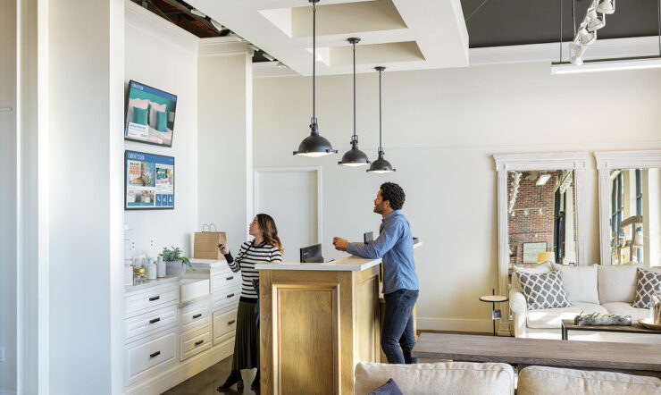 Female employee in commercial retail store providing customer support for male shopper.