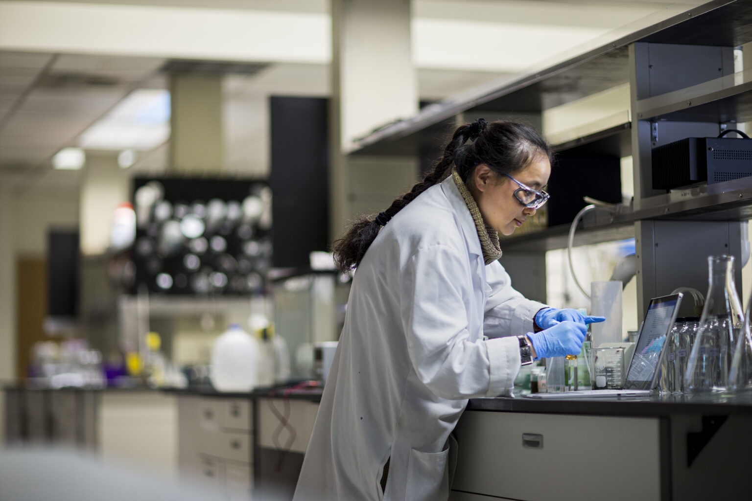 Asian female scientist working in a lab with conical flasks