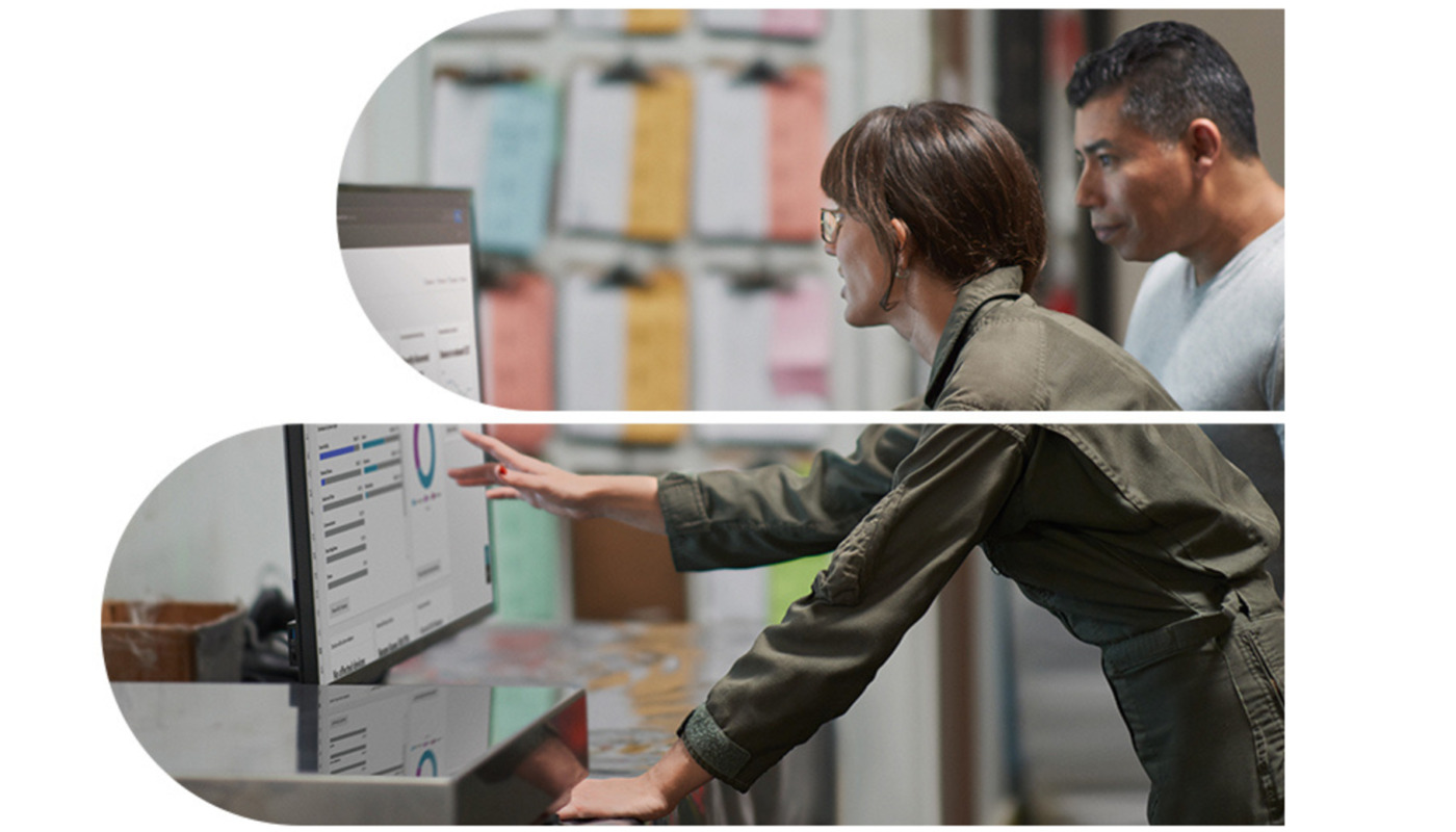 A man and a woman looking at a screen showcasing a dashboard