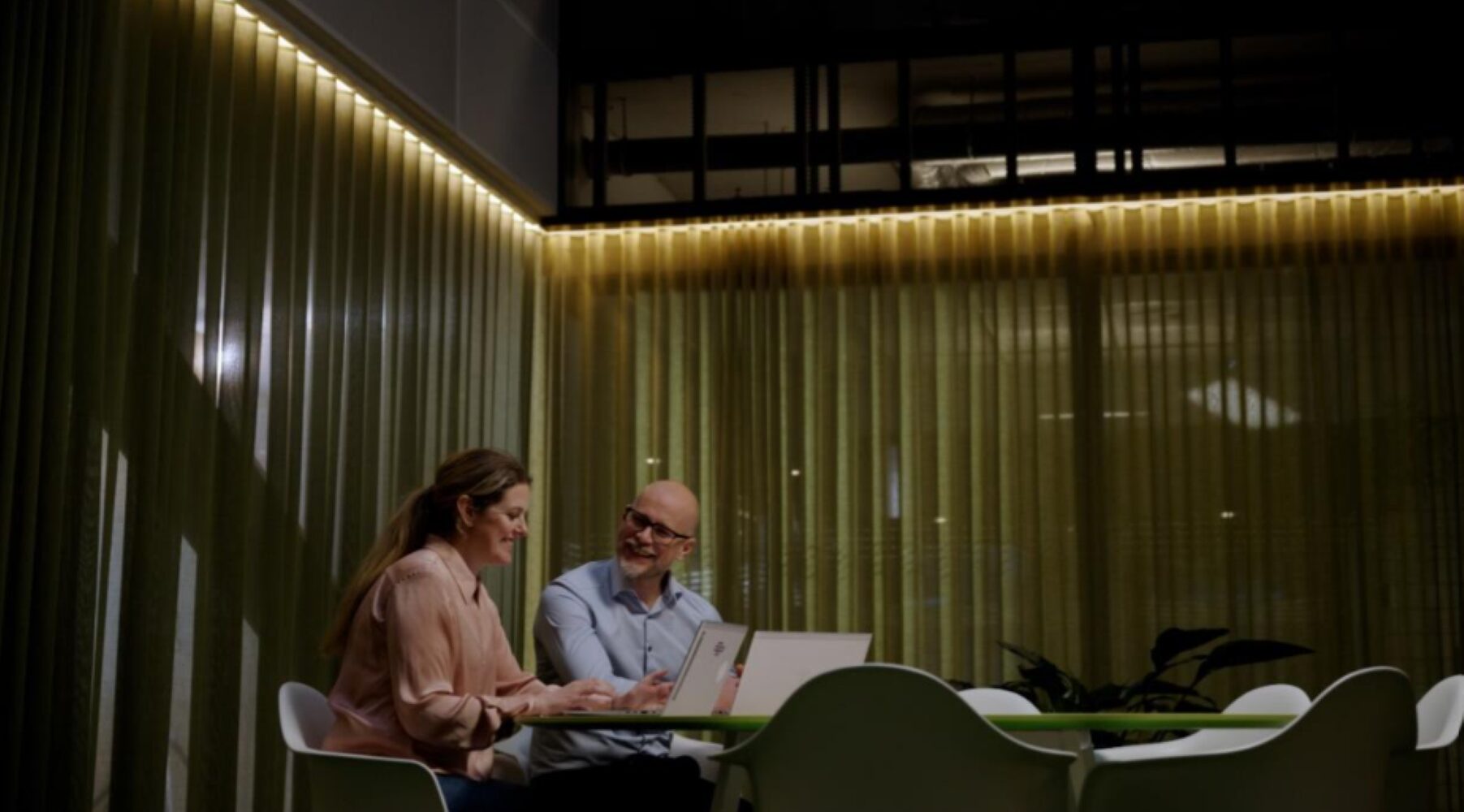 Image of one women and one man sitting with a computer