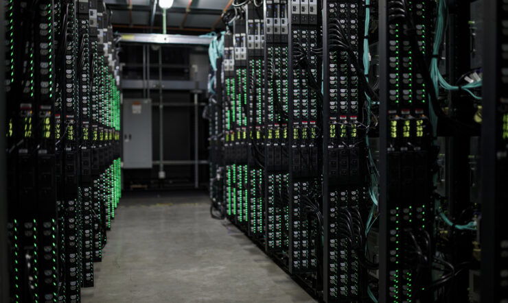 Hallway view of servers in hot aisle. Green tones, no people.