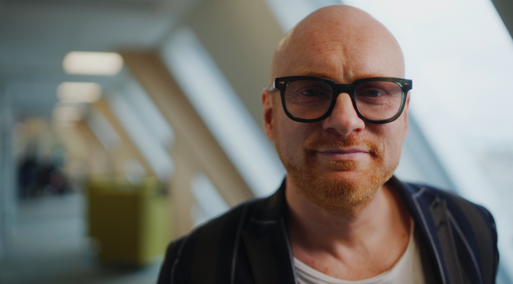 A portrait of a man with a blurry office in the background