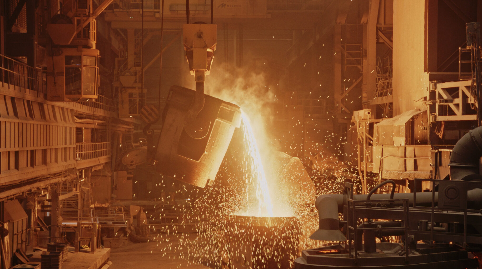 Hot melted glowing metal being poured in a modern forge