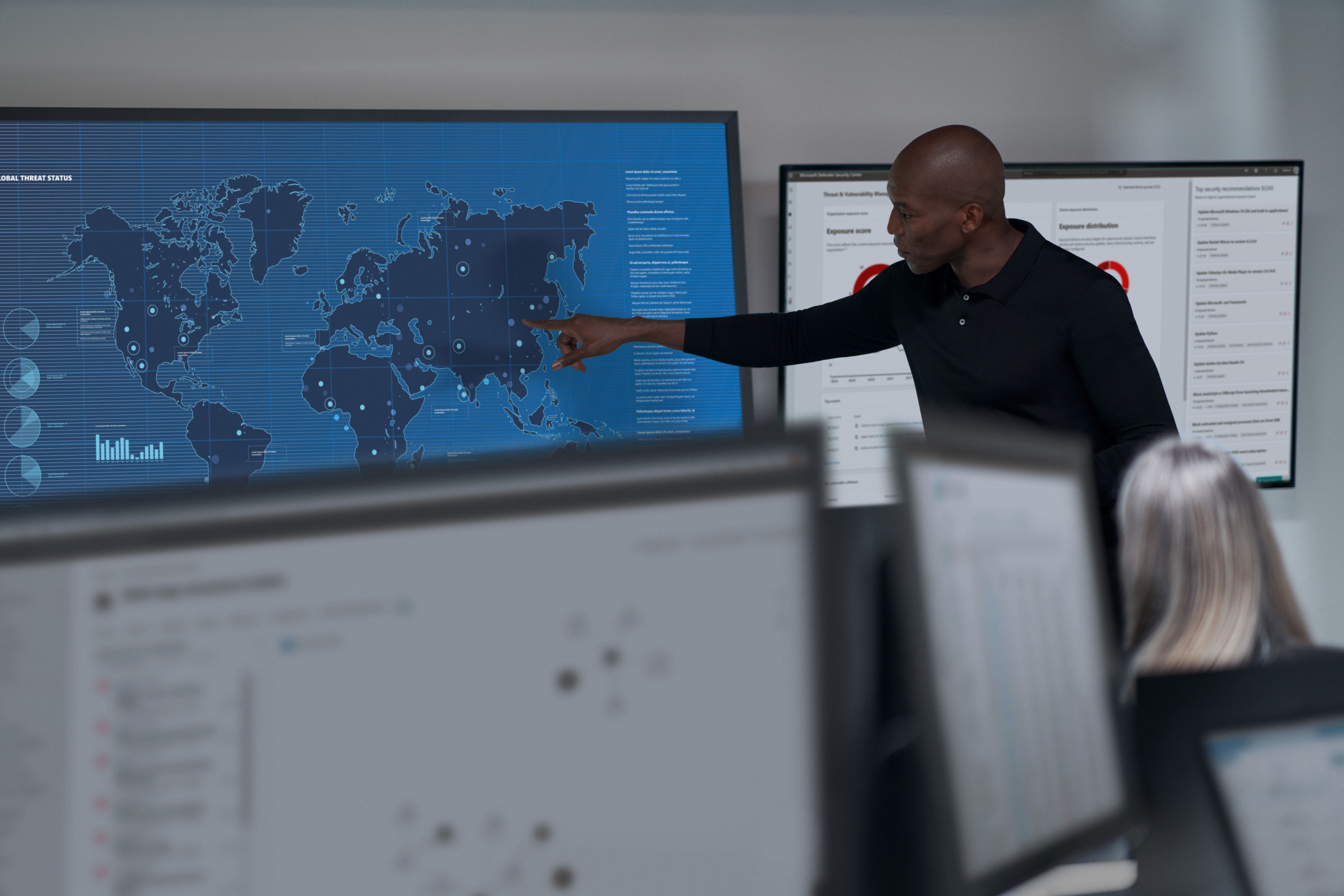 CISO (chief information security officer) collaborating in a security operations center. Keywords: Security; operations; man; wall map; soc; war room; Microsoft Defender for Cloud; threat hunting