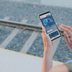 Person looking at a phone, at a train station