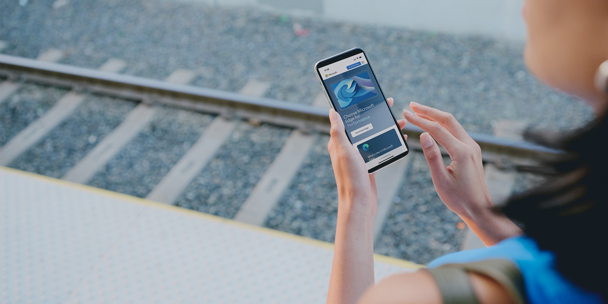 Person looking at a phone, at a train station