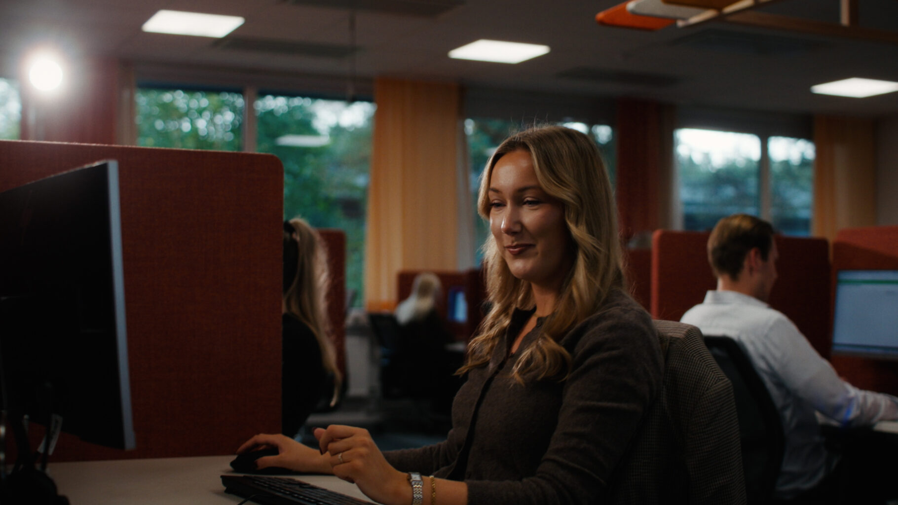 Närbild på en person som sätter på sig ett headset på kontoret.